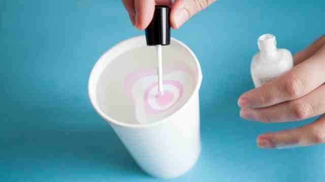 Add a drop of nail polish into a cup of cold water, optionally add another colour or two and dip your finger into the solution where the nail polish is. Once its decently dry use a cotton bud or flake to remove the nail polish off of then skin around your nail. This is called marble affect