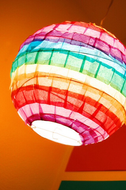 Get a paper lantern and tissue paper in various colours. Cut the tissue paper in squares and glue them on to paper lantern .
