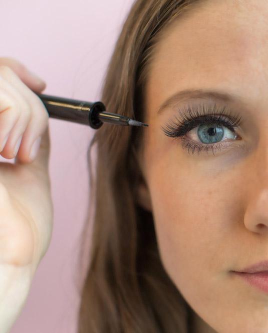 25. After you've applied false lashes, use black liquid liner to blend the strip with your real lashes.