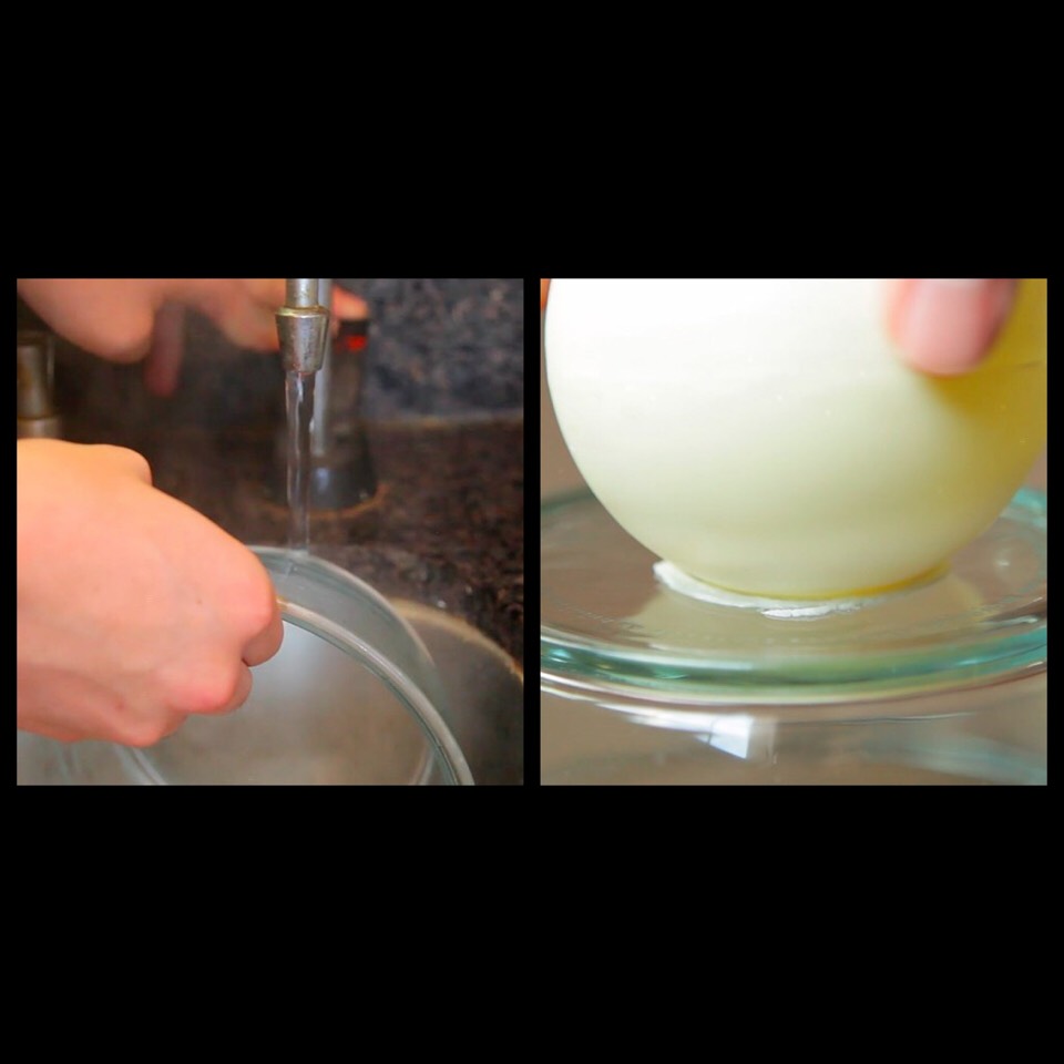 5. Next, make a small hole on the bottom of the whole thing:
Do this by running hot water over a flat bowl or plate, drying it, then putting the chocolate bomb on it and twisting gently. This will melt the bottom of it, creating a hole for the sundae filling.