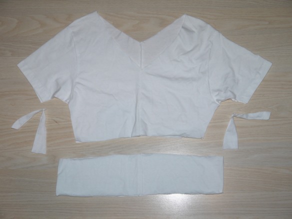 You take it apart and shorten the bodice. You can also cut underneath the sleeves for a more curved batwing look.

Sew it again following the same process. 

To save yourself the trouble of having to redo, make sure that the bodice is the right length at the beginning. 
